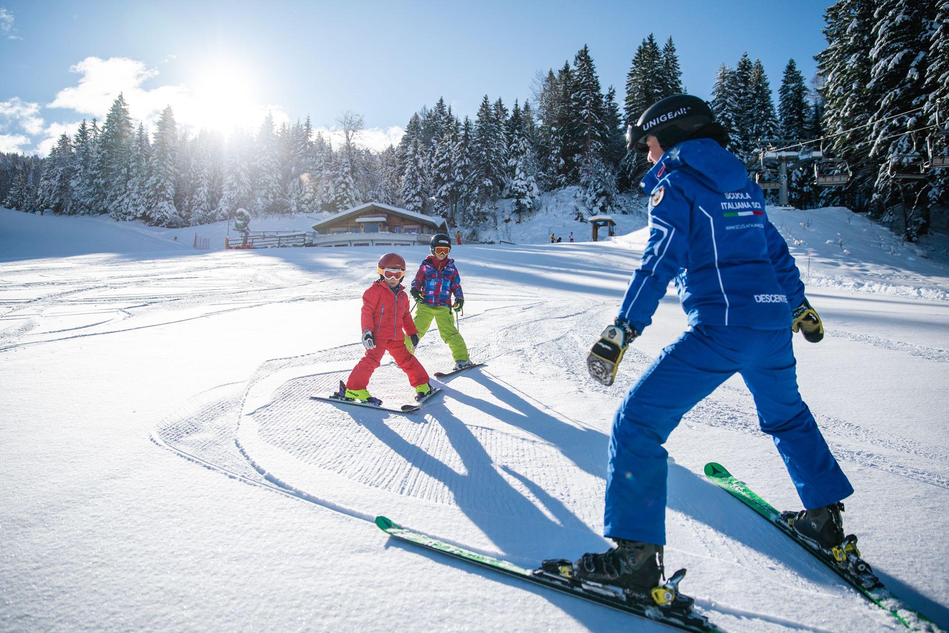 Lezione di sci per bambini e bambine sulle piste della Ski area Paganella.